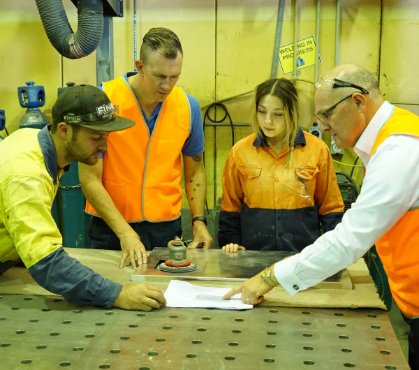 Sevaan Group - Great leaders Busy geoup of engineers wearing orange uniform discussing the design